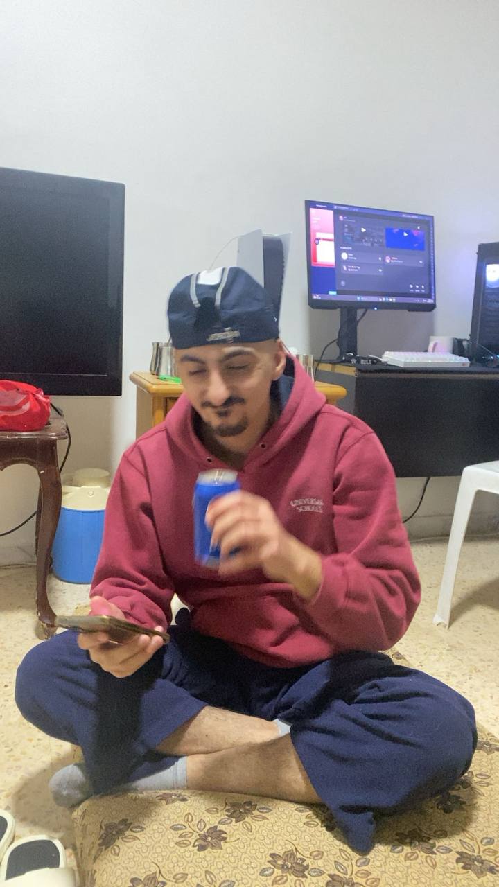 Zaid sitting on carpet drinking Pepsi